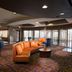 Courtyard by Marriott Fayetteville lobby lounge with orange sectional seating and floor-to-ceiling windows