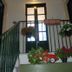 Al Mare in Citta in Catania: flower-filled stair landing with black railing and windowed door
