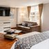 Hotel Porton De La Cabrera room in Bogotá with sofa, chair, wall TV, and large windows