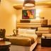Hotel Royal Qosqo Cusco room with bed, tufted chair, wall art and bedside lamp