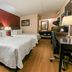 Red Roof PLUS+ Nashville South - Fairgrounds guest room with two beds, desk and wood flooring in Nashville