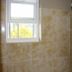 Prince of Wales Motel bathroom with tiled shower, wall-mounted fixtures, and a frosted window in Lake Wales