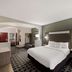 Quality Inn & Suites Irving DFW Airport South guest room with king bed, seating area and carpeted floor