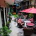 Hotel Royal Qosqo in Cusco courtyard with red umbrella, wicker seating and potted plants