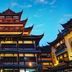Home Inn Style Shanghai Railway Station Zhongxing Road Metro Station in Shanghai, illuminated pagoda-style building at dusk