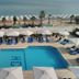 Santa Beach Hotel in Agía Triáda with outdoor pool, sun loungers, umbrellas, and sea view