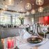 Fletcher Hotel Landgoed Huis te Eerbeek restaurant with set tables, hanging lights and red wall decor in Eerbeek