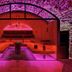 Königshof Hotel Resort in Oberstaufen, a pink-lit spa lounge with arched stone walls and wooden benches