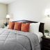 Intown Suites Extended Stay Lewisville Tx - East Corporate Drive room with queen bed and gray bedding