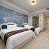 Hong Yun Dong Du Hotel in Qingdao room with two beds, floral mural wall, and vanity desk