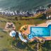 Golden Tulip Dar Es Salaam aerial view of oceanfront pool, terrace and palm trees in Dar Es Salaam