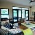 Sandton Lodge Rivonia in Johannesburg living area with sofa, coffee table, shelves, and glass doors