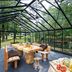 Fletcher Hotel-Restaurant De Buunderkamp in Wolfheze: glass pavilion dining area with rustic tables and garden views