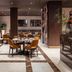 Worldhotel Cristoforo Colombo Milan restaurant with round tables, mustard chairs, and marble flooring