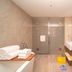 Zhucheng Huaxi Grand Hotel in Rizhao bathroom with twin sinks, shower, towels, and yellow bucket