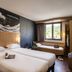 ibis Cannes Mouans-Sartoux room with twin beds, window seat, and wave wall art in Mouans-Sartoux