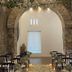 Hotel Boutique Casareyna in Puebla City: stone arch venue with rows of black chairs and floral aisle
