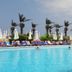 Lamedina Hotel & Resort in Jounieh: outdoor pool with loungers, umbrellas, palm trees, and sea view