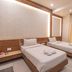 Hotel G Shy Bhopal twin room with two single beds, bedside table, and floor-length curtains