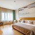 Clovelly Garden Hotel Shanghai guest room with king bed, desk, chairs and window with curtains
