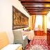 Art Palace - Residenza Giardini in Venice: cozy room with wooden beams, red rug, dresser and window seating