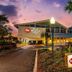 Best Western Plus Yacht Harbor Inn in Dunedin at sunset with palm trees and illuminated exterior