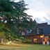 Ravenwood Hall Hotel in Bury St. Edmunds, brick country hotel exterior at dusk with lit windows and garden