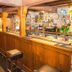The Manor House Hotel in Dronfield bar area with wooden counter, stools, beer taps and bottle display