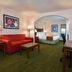 Lamplighter Inn & Suites At Sdsu in San Diego with red sofa, desk, and bedroom alcove