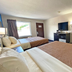 Red Carpet Inn Orchard Park guest room with two beds, TV, desk and window in Orchard Park