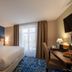 Hôtel Le Yachtman, La Rochelle guest room with king bed, desk, TV and sheer curtains by the window