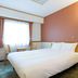 Toyoko Inn Takamatsu Hyogomachi guest room with double bed, desk, chairs and large window in Takamatsu