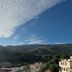 Hotel Mirasol in Órgiva with mountain views under a dramatic cloud-filled blue sky