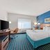 Comfort Inn & Suites Berea guest room with king bed, desk, TV, and blue geometric accent wall in Berea