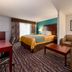 Sunset Motel Hood River guest room with king bed, seating area, desk and window view in Hood River