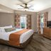 Club Wyndham Nashville bedroom with king bed, ceiling fan, TV, dresser, and patterned curtains