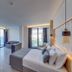 Signature Blue Resort Kusadasi room with balcony sea view, seating area, and modern bed in Kusadasi