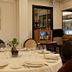 Hotel Fraga do Eume in Capela dining room set with a round table, plates, wine glasses and framed wall art.
