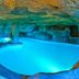 Playacartaya in Cartaya: illuminated indoor cave-style pool with rock ceiling and turquoise water