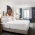 Spark by Hilton Plainfield Indianapolis Airport guest room with king bed, window, TV, and open wardrobe