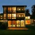 Vitalhotel Die Mittelburg in Oy-Mittelberg at dusk, lit windows and a spacious lawn