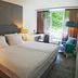 Parkhotel Fritz Am Brunnen in Schwelm, guest room with twin beds, desk, armchair and window view.