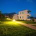 Kyparissia Blue Boutique Hotel in Kyparissía with lit garden path and modern white villas at dusk