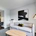 Homewood Suites by Hilton Louisville-East living room with sofa, table, floor lamp and open kitchen