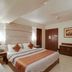 Hotel Centra-Ahmedabad guest room in Ahmedabad with king bed, wall art, wardrobe, and dresser