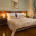 Judita Palace Heritage Hotel in Split bedroom with ornate bed, draped curtains and bedside lamps