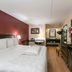 Red Roof PLUS+ Nashville South - Fairgrounds room with king bed, desk, dresser and TV in Nashville