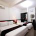 Hanoi Crystal Hotel Hanoi room with two beds, desk, chair, air conditioner and wall mirror