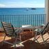 Hotel Lido Mediterranee in Taormina with balcony chairs overlooking the sea and boats