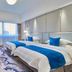 Zhucheng Huaxi Grand Hotel in Rizhao guest room with two beds, wall-mounted TV, desk and large window